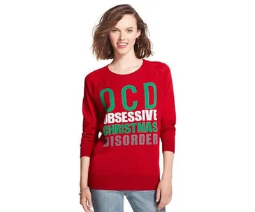 A person wearing a red sweater with the text "OCD: Obsessive Christmas Disorder" in bold colors.
