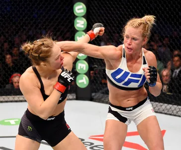 Two UFC fighters in action, one delivering a punch during a fight inside the octagon.
