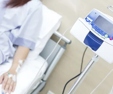 Patient receiving IV chemotherapy, infusion pump in focus.