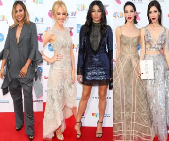 Four women in stylish outfits on the ARIA Awards 2015 red carpet, posing for photos.