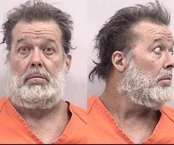 Mugshot of a man with a beard in an orange jumpsuit, facing forward and in profile.