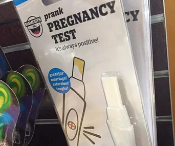 Prank pregnancy test packaging, labeled "always positive," on store shelf.