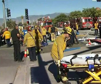 Emergency responders at a scene with fire trucks and stretcher in California after a shooting.
