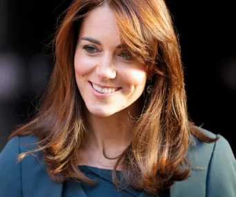 "Duchess of Cambridge with new hairstyle, smiling in natural light."