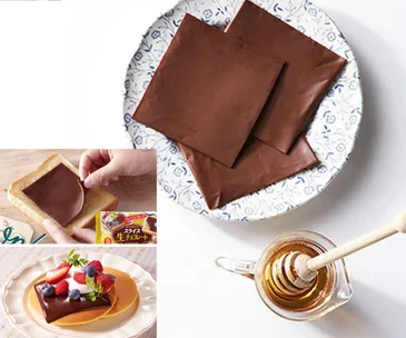 Slices of chocolate on a plate, used on toast and pancakes with berries and a jar of honey nearby.