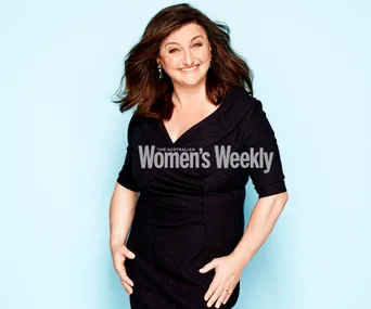 Julie Goodwin smiling in a black dress against a light blue background, from The Australian Women's Weekly.