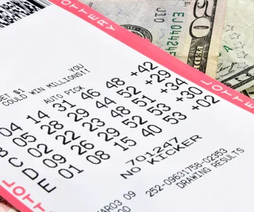 Lottery ticket showing numbers with cash underneath.