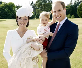 A family of four, dressed formally, posing outdoors with trees in the background.