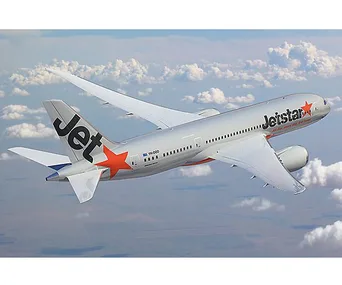 Jetstar airplane flying above clouds, showcasing brand logo with orange star on tail and engine.