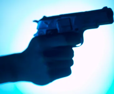 A silhouette of a hand holding a handgun against a blue gradient background.