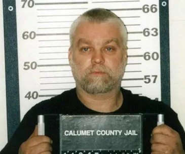 Mugshot of a man with gray hair and beard holding a "Calumet County Jail" sign, standing in front of a height chart.