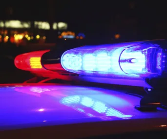 Police car with flashing red and blue lights at night.
