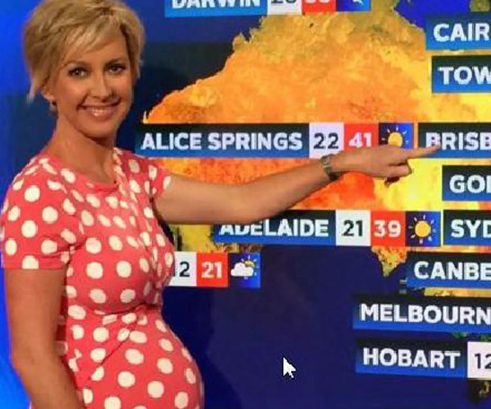 Weather presenter in a polka dot dress points at a map displaying temperatures in Australia.