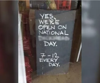Sign reads: "Yes, we're open on National _______ Day. 7-12 every day." The blank word is obscured.