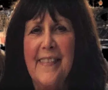 A woman with long dark hair smiling warmly at the camera.