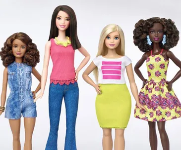 Four Barbie dolls with diverse body types and outfits, standing together against a white background.