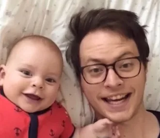 Father and baby smiling while recording a Dubsmash video together.