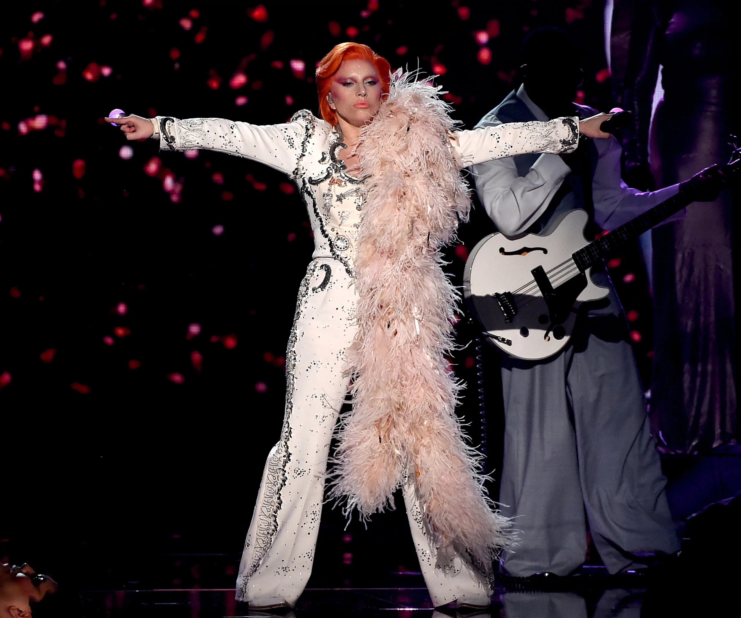 Lady Gaga performs David Bowie tribute at 2016 Grammys, wearing embellished suit with pink feather boa.