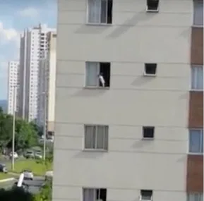 Toddler seen at open third-story window of an apartment building.