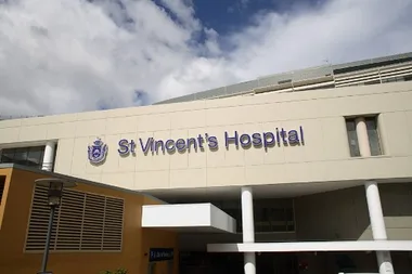 St Vincent's Hospital building exterior with sign, cloudy sky above.