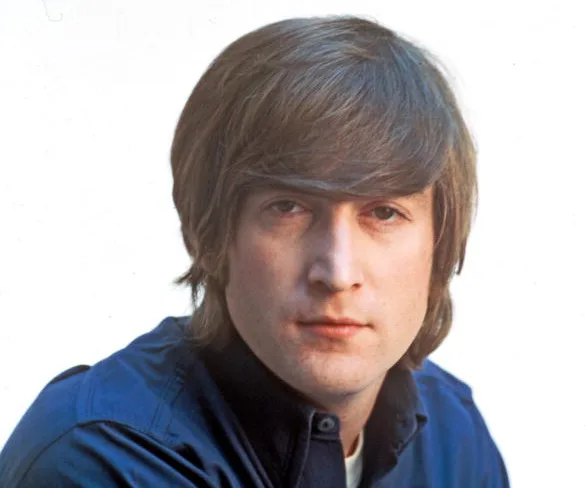 Portrait of John Lennon with mid-length hair and a serious expression, wearing a dark blue shirt.