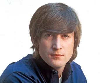 Portrait of John Lennon with mid-length hair and a serious expression, wearing a dark blue shirt.