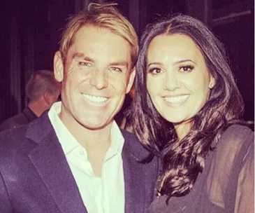 ```
A man and a woman smiling together at an event.
```