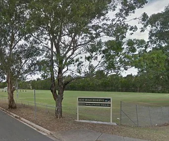 Park with trees and a sign reading "Best Road Reserve, Bullinger Fields" near a road.