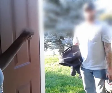 "Man with bag stands outside a door as a person inside opens it, scene is outdoors with trees in background."