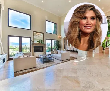 Luxurious living room with large windows, high ceiling, beige sofas, and a fireplace; inset of a smiling woman.