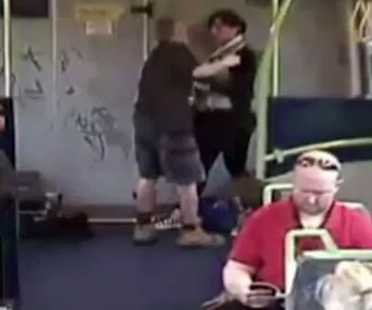 A man appears to choke a woman on a Melbourne train, with passengers nearby and graffiti on the walls.