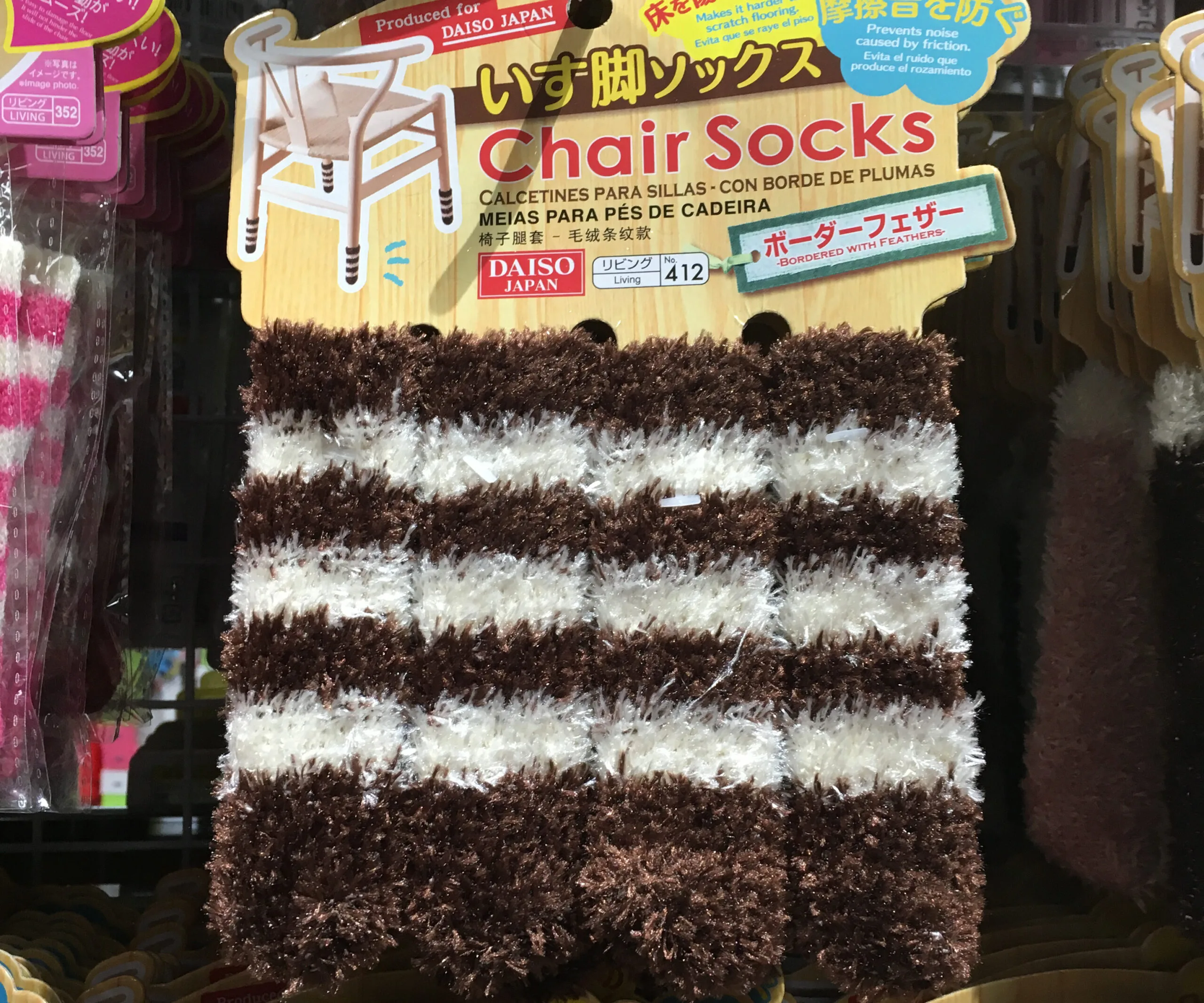 Fluffy brown and white striped chair socks labeled "Daiso Japan," designed to protect floors from scratches.