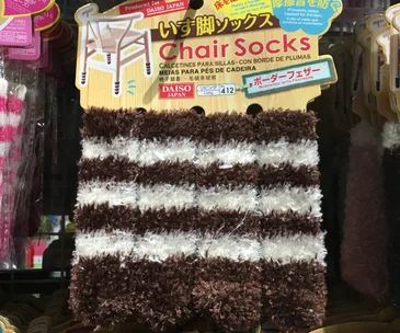 Fluffy brown and white striped chair socks labeled "Daiso Japan," designed to protect floors from scratches.