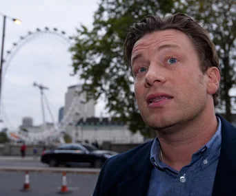 Man speaking outside with London Eye in the background.