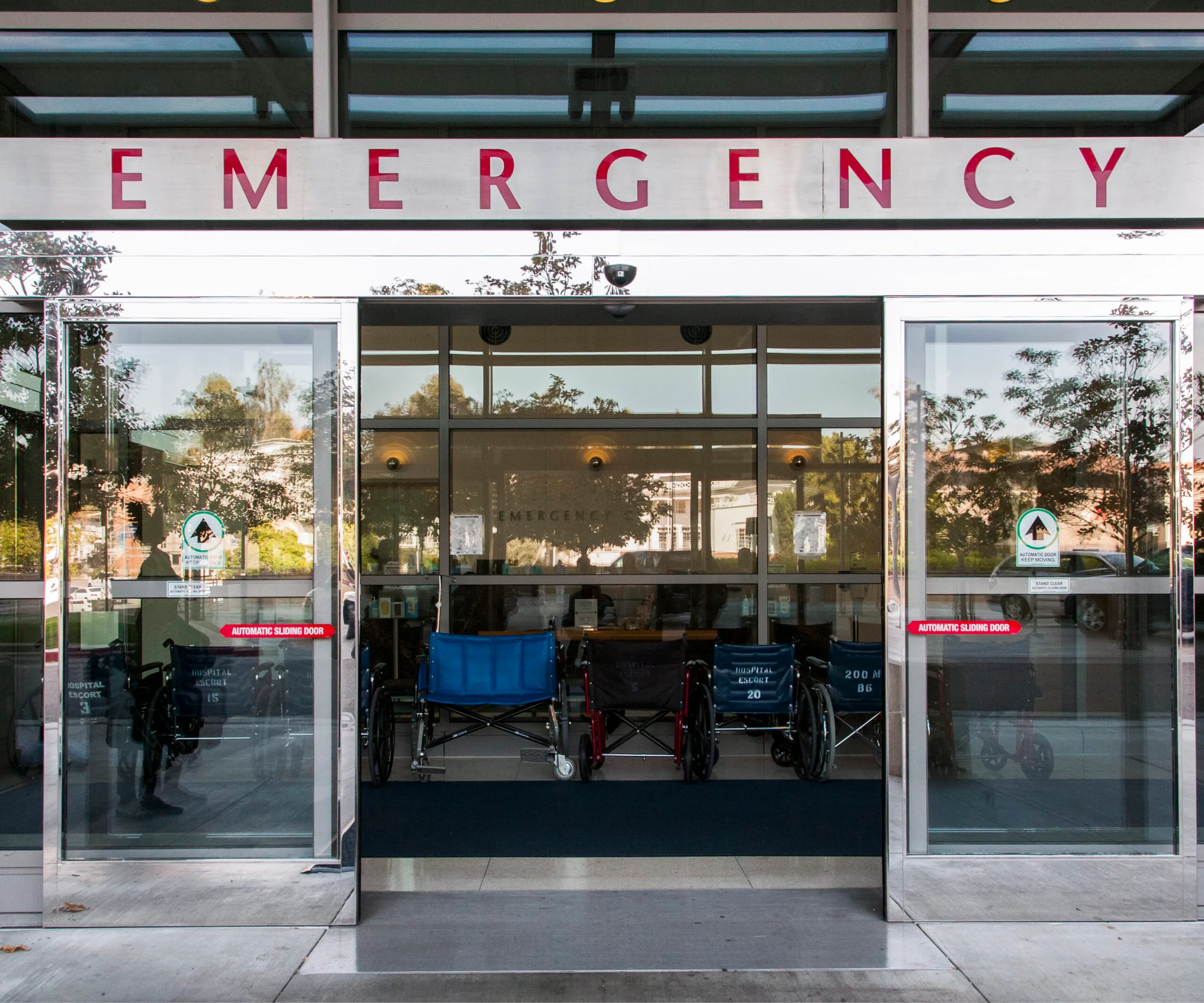 Hospital emergency room entrance with wheelchairs outside.