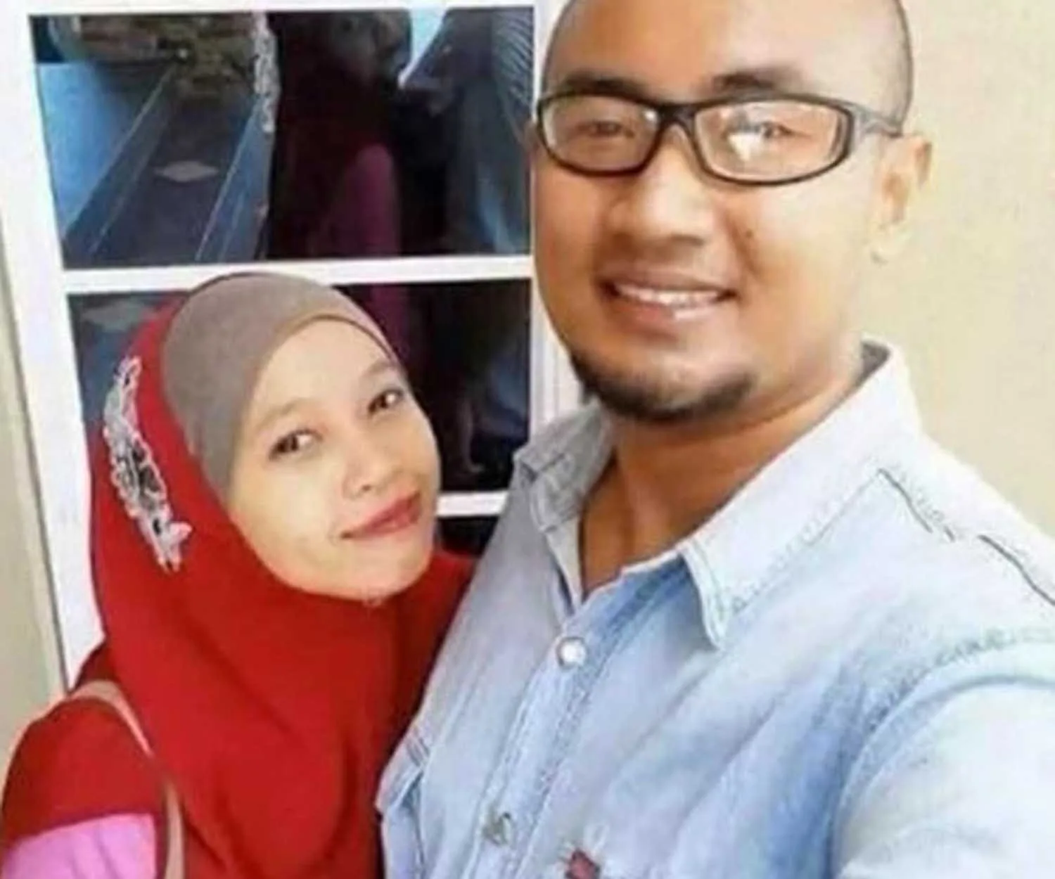 A couple taking a selfie with a smiling reflection of the woman appearing on the glass door behind them.
