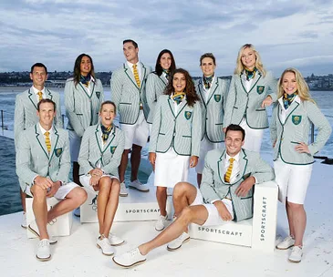 Australian Olympic team members in green blazers and white shorts pose for the 2021 Tokyo Games opening ceremony.