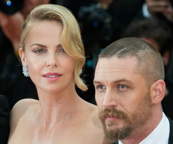 Charlize Theron and Tom Hardy at a formal event, possibly related to "Mad Max: Fury Road."