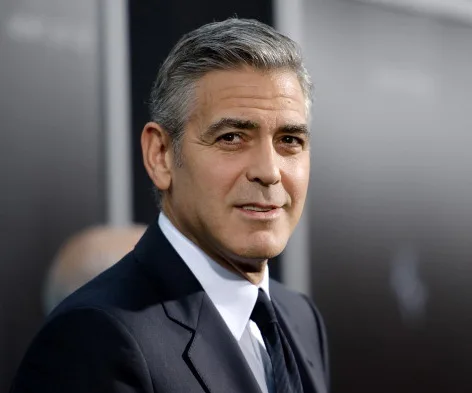 Actor in a suit at a formal event, facing the camera with a neutral expression.