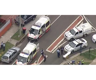 Aerial view of emergency responders at a road incident scene with several police and ambulance vehicles.