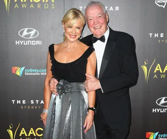 Couple smiling on the red carpet at the AACTA Awards in formal attire.