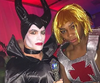 Two people in costume: one as Maleficent with horns, and the other as He-Man with a blond wig and armor.
