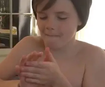 A young boy with a beanie clapping his hands, appearing focused and content.