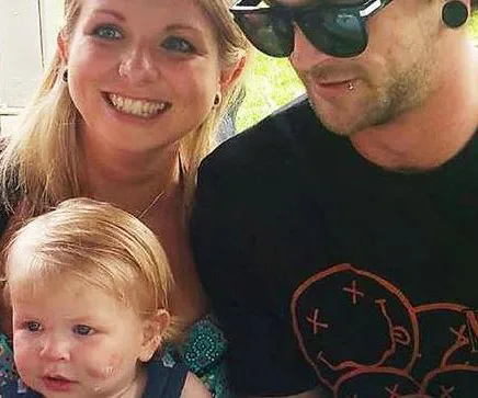 Family photo of a smiling woman, a man in sunglasses, and a young child outdoors.