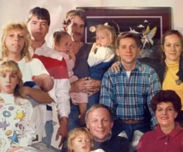 Family portrait featuring adults and children; a fairy painting is in the background.