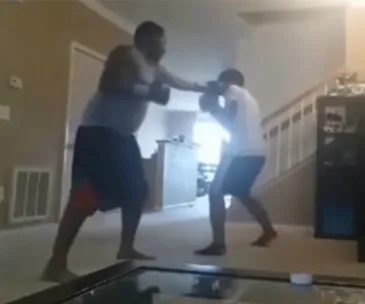 Father and son in living room, father appears to punch son.