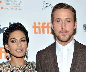 "Two individuals posing at an event with a TIFF backdrop, wearing formal attire."