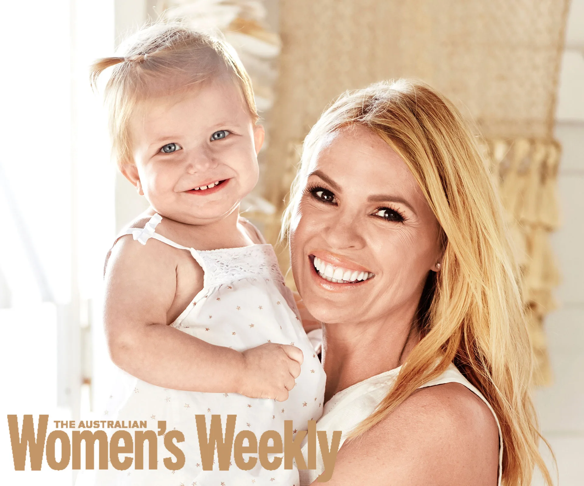 Smiling woman holding a baby, featured on The Australian Women's Weekly cover.
