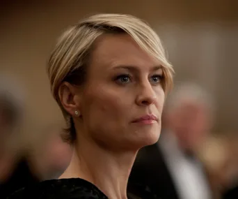 Claire Underwood, portrayed in a formal setting, serious expression, short blonde hair, from "House of Cards."