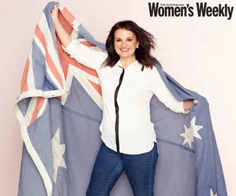 A woman in a white shirt holds an Australian flag while smiling, with "The Australian Women's Weekly" in the top corner.
